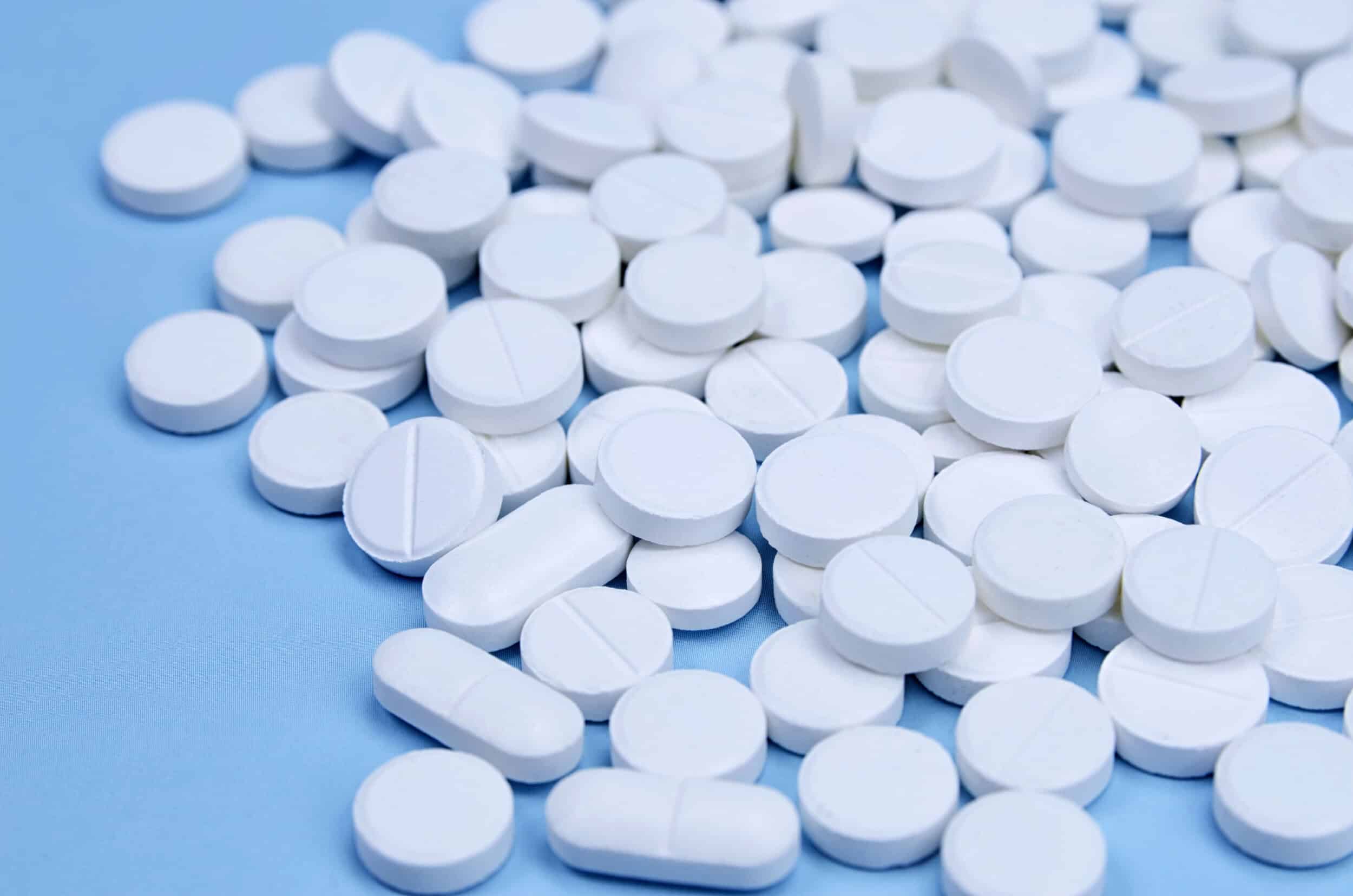 Inspection des comprimés à l'aide de l'IA 2 newly produced white pills on a blue surface