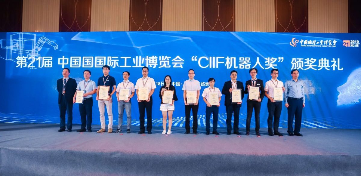Photograph of Solomon team representatives standing on stage to receive the CIIF 2019 Robotics Award for AccuPick 3D in Shanghai, with the award details displayed on the backdrop.