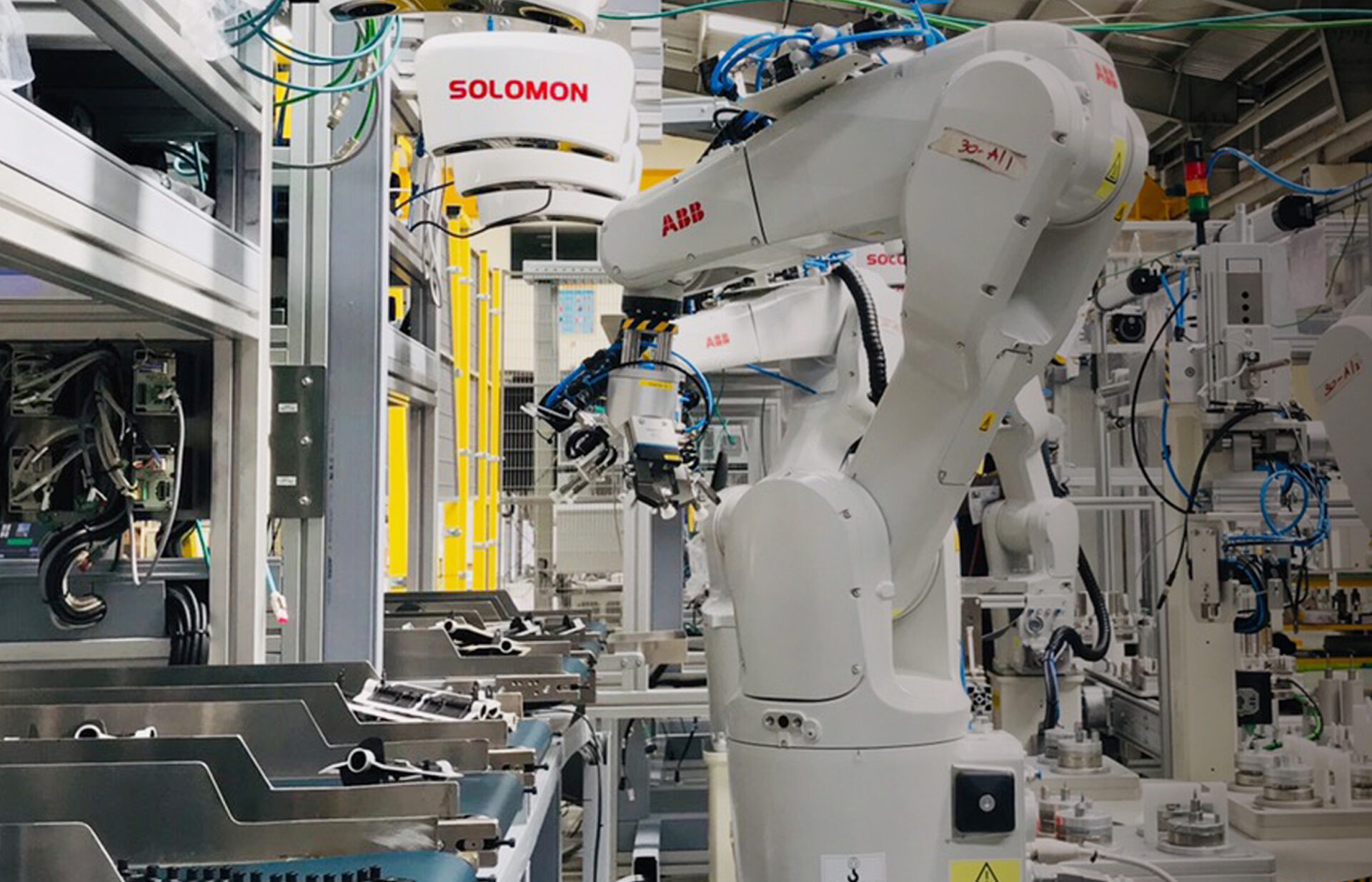 3D-Vision-geführtes automatisiertes Picking Ein ABB-Roboter am Arm einer automatisierten Montagelinie führt eine Kitting-Aufgabe mit Solomon AI und 3D-Vision-Technologie aus.