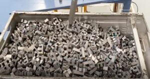 Robotic bin picking of randomly oriented steel switchgear parts from a metal bin in a manufacturing cell, showcasing industrial AI vision automation.
