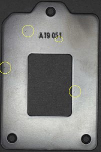 A close-up image of a metallic hardware casing showing several tiny nicks and micro-defects highlighted by yellow circles, demonstrating the ability of AI to detect even the smallest flaws during quality control.