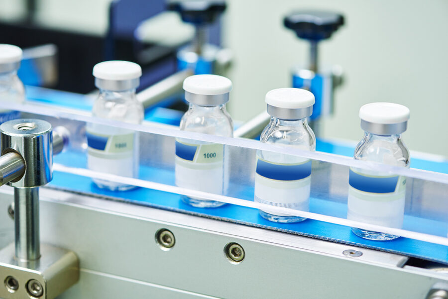 Farmacêutico e Médico Linha de produção farmacêutica com frascos de medicação injetável.